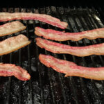 bacon cooked on a dirty grill.